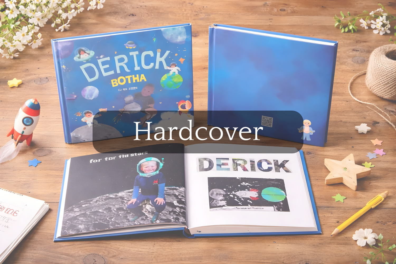 Personalized hardcover book with 'DERICK' on a wooden surface with decorative items.